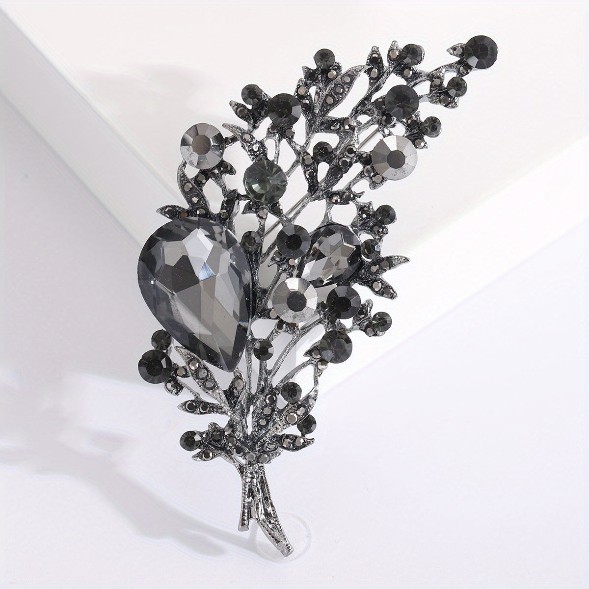 High-quality imitation crystal brooch with luxurious leaf design for women and men. Features exquisite rhinestone details, making it a beautiful and high-end accessory.