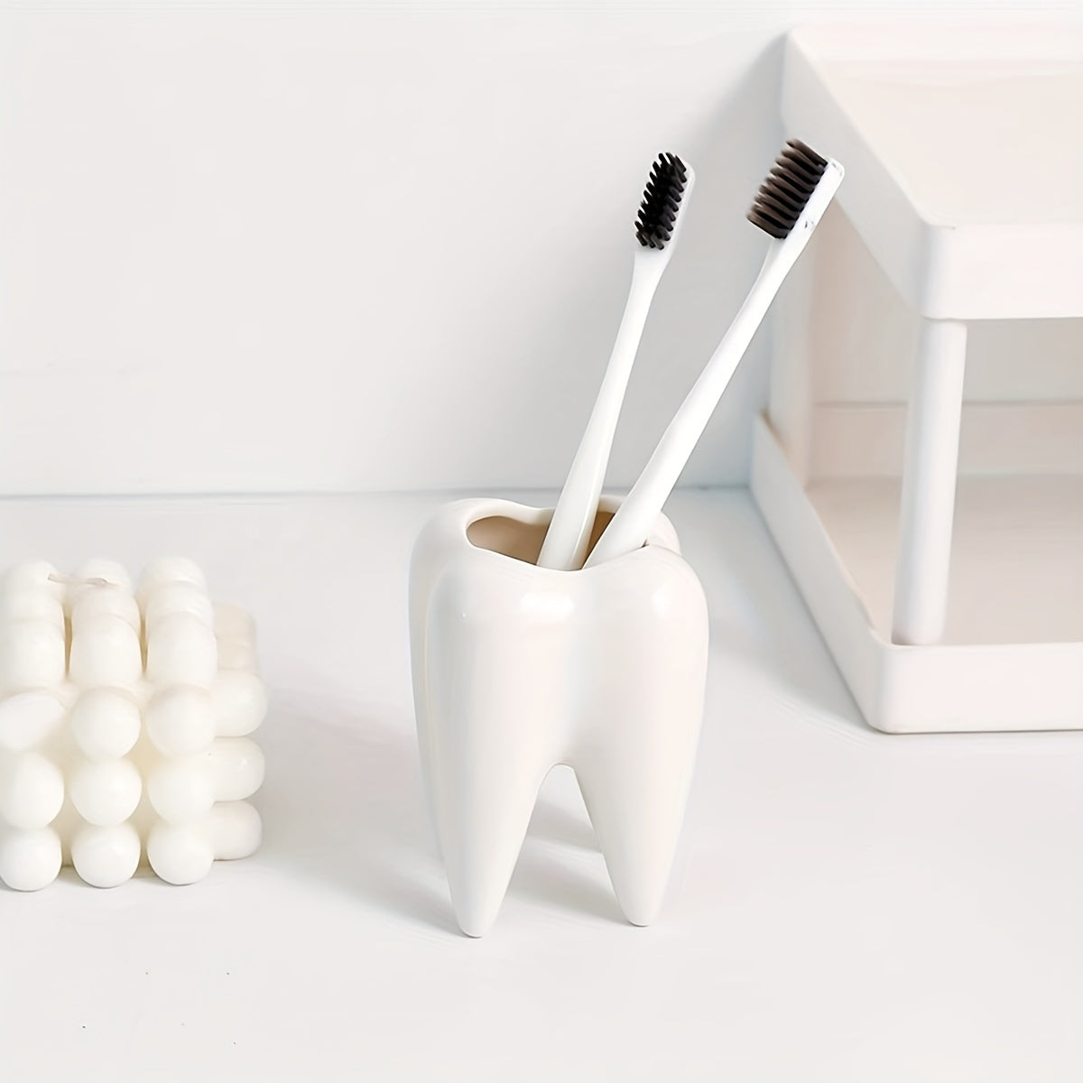 Tooth-shaped ceramic pen holder for desk or bathroom storage.