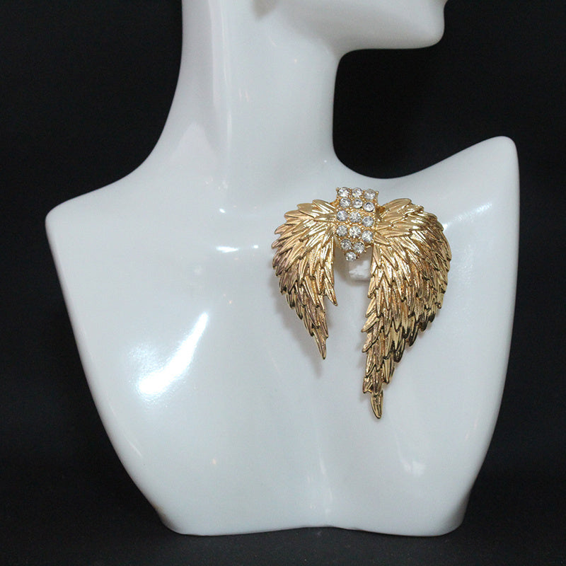 Luxurious and elegant brooch pin featuring golden-winged feathers adorned with sparkling rhinestones - a unique accessory that adds a touch of retro glamour to any outfit. Perfect for women who appreciate timeless style and sophistication.