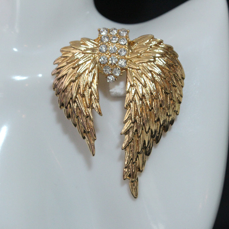 Luxurious and elegant brooch pin featuring golden-winged feathers adorned with sparkling rhinestones - a unique accessory that adds a touch of retro glamour to any outfit. Perfect for women who appreciate timeless style and sophistication.