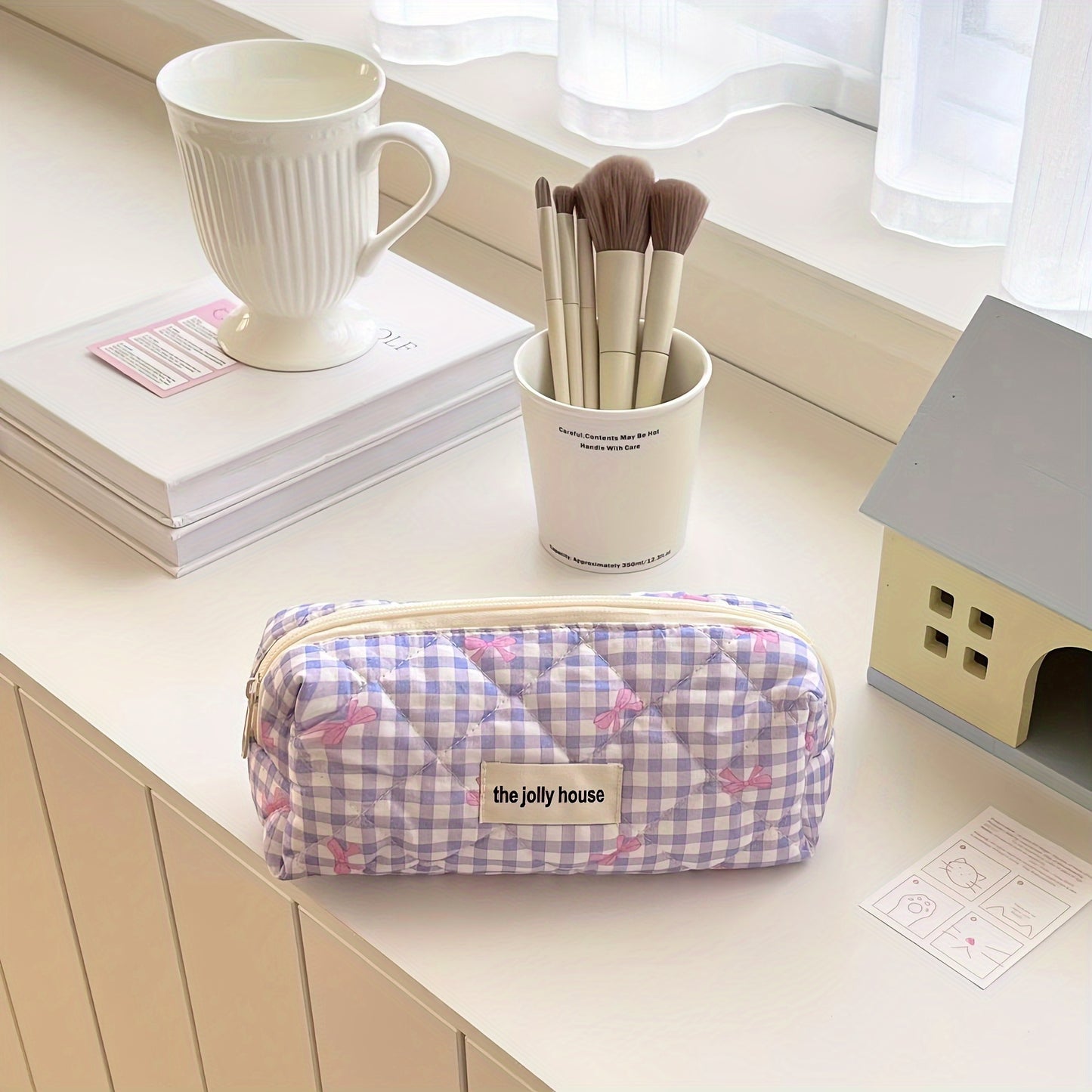 Polyester plaid pencil case with bowknot design for women and girls.