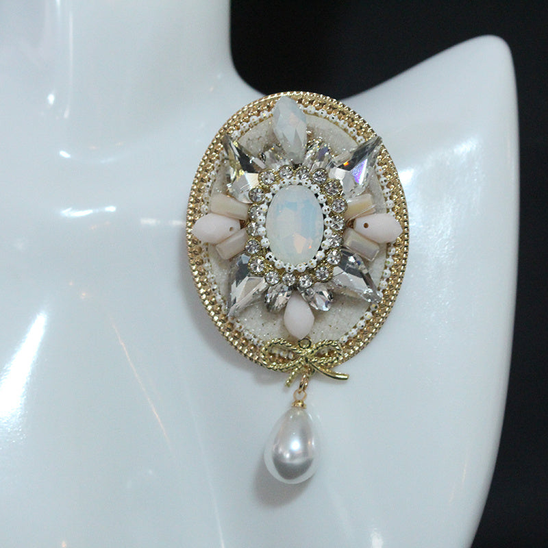 Stylish and Opulent Unique Brooch Adorned with Faux Pearl Pendant, Oval Design, Fashionable and Trendy Accent.