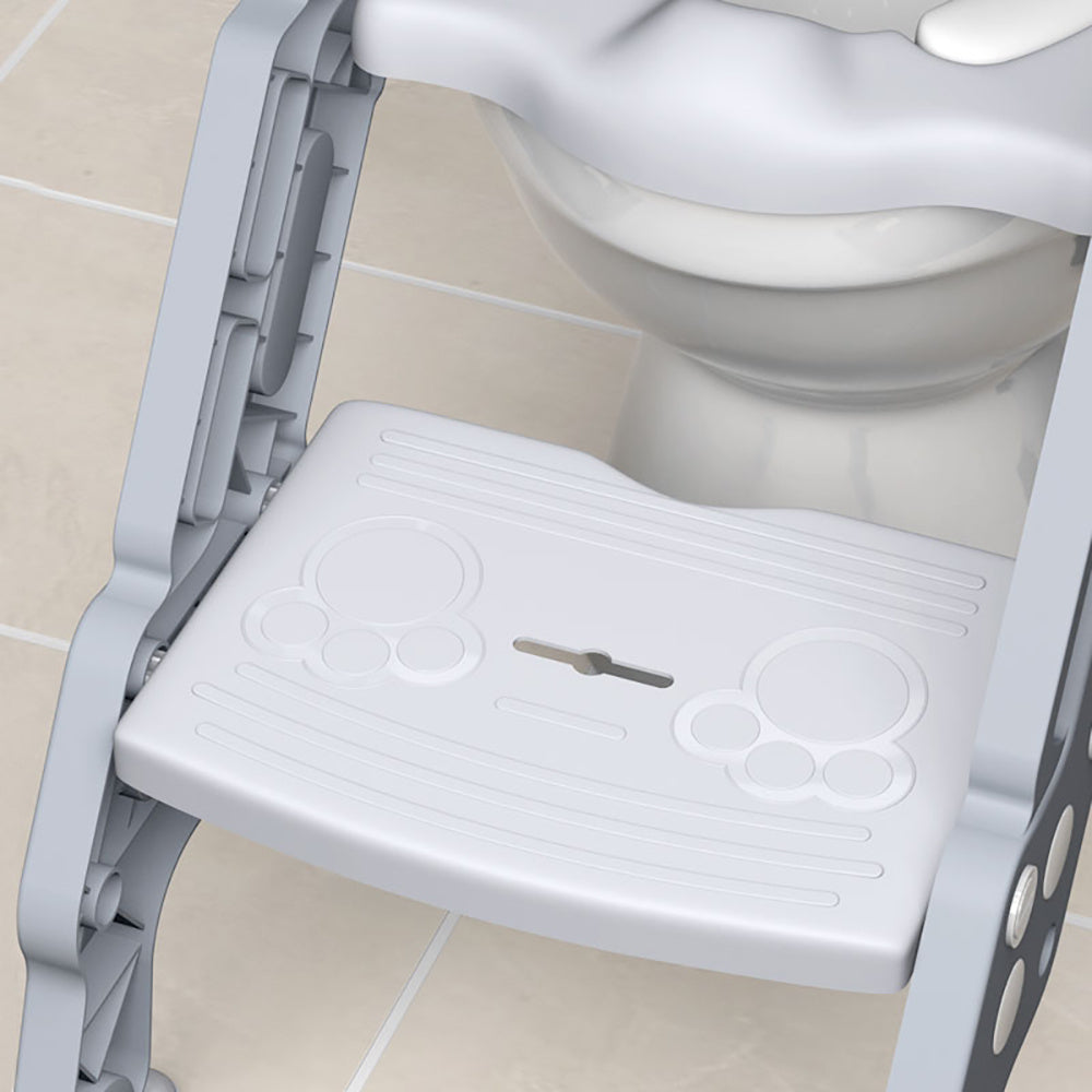 A folding staircase-type children's toilet seat with an auxiliary stool cushion for a baby girl or baby boy in the household restroom.