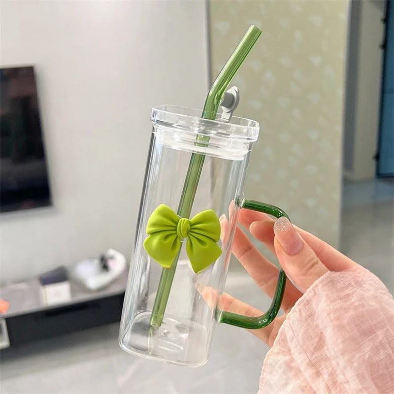 Clear Glass Mug with Handle features a bow decoration on a square drinking cup. This high-temperature resistant mug comes with a straw, perfect for enjoying coffee, milk, or water. Ideal for use at home, in the kitchen, or at parties.