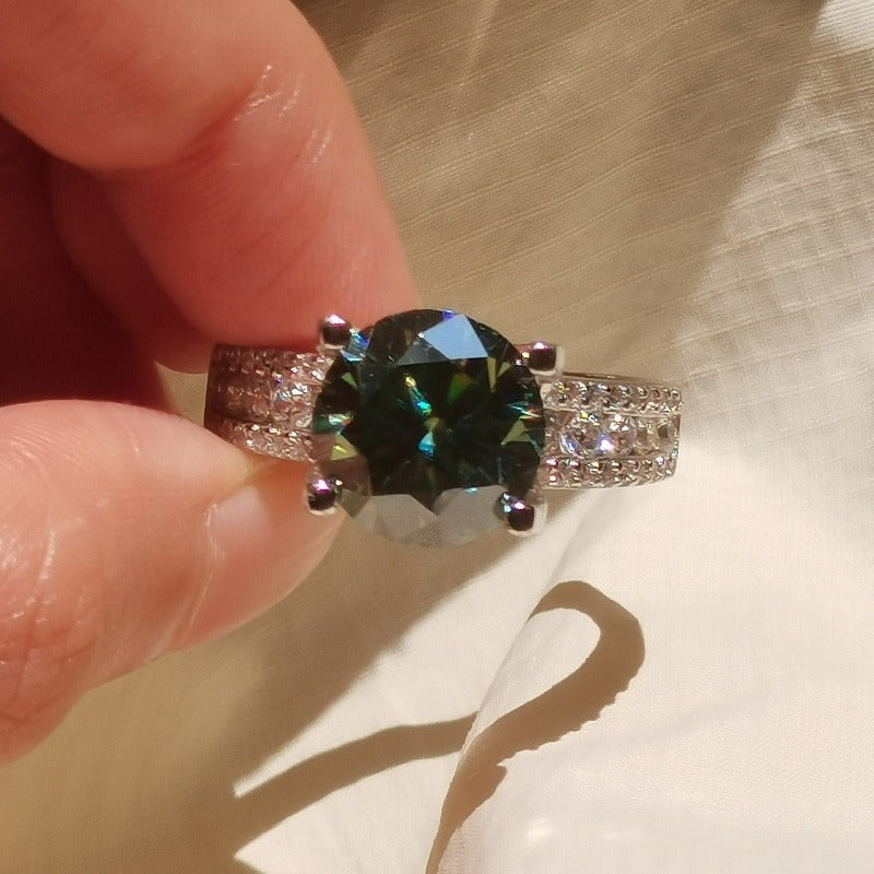 Moissanite Ring with 1 piece stone, 3/5/10 carats, set in 925 Sterling Silver with 18K Golden Plating. Features a 4-prong setting in a beautiful blue-green color. This elegant ring is perfect for vacations, proposals, music festivals, and sports.