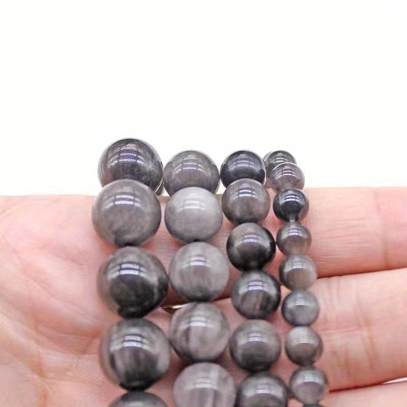 XULIN offers a set of 6/8/10mm Natural Stone 7A Silvery Obsidian Beads, perfect for DIY jewelry making. These lustrous round faux gemstones can be used to create beautiful necklaces, bracelets, and earrings. Ideal for crafting fashionable and romantic