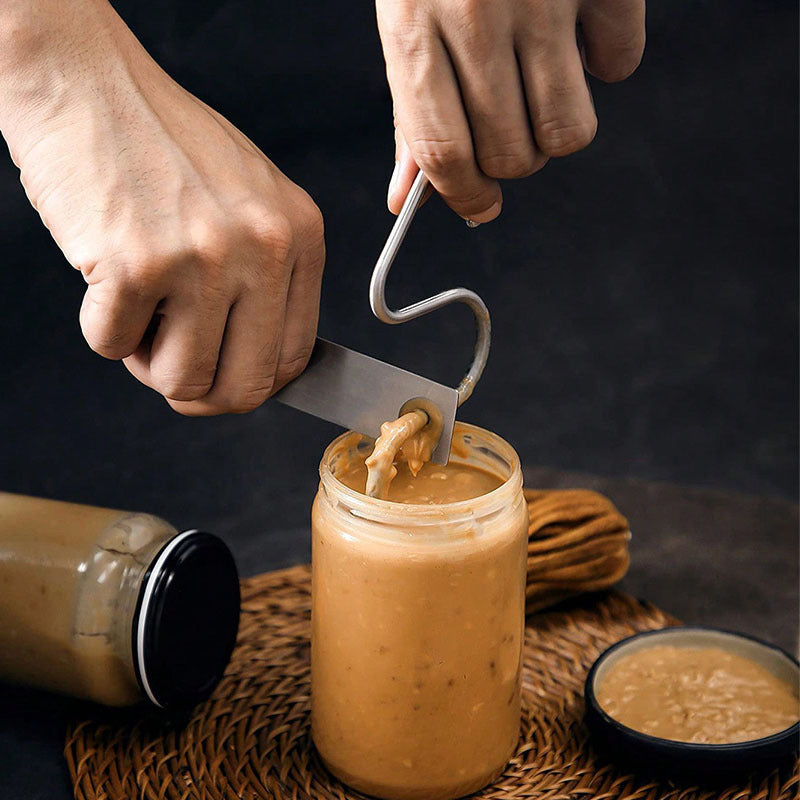 A manual stirring tool with scraper for mixing peanut butter made of stainless steel.