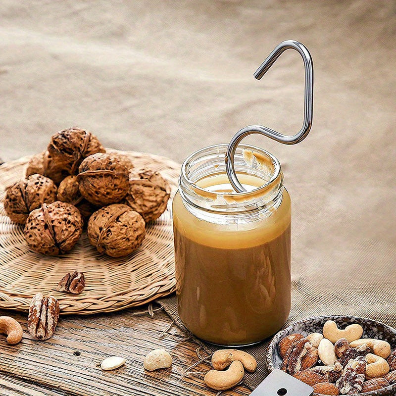 A manual stirring tool with scraper for mixing peanut butter made of stainless steel.