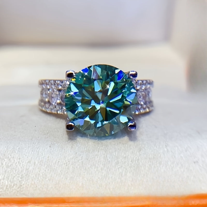 The 925 sterling silver promise ring features an elegant 10ct blue-green Moissanite stone in a 4-prong setting. It is hypoallergenic and coated with 18K golden plating, making it an ideal choice for daily wear or as a gift for Valentine's Day. This ring