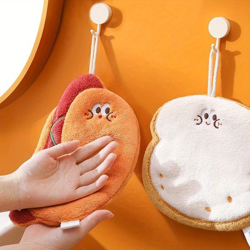 Cartoon food shaped hand towel made of soft coral fleece, quick-dry and absorbent for bathroom or kitchen use. Features designs of cheese, bread, and cookies, can be used as hanging wipe cloth. No electricity required.