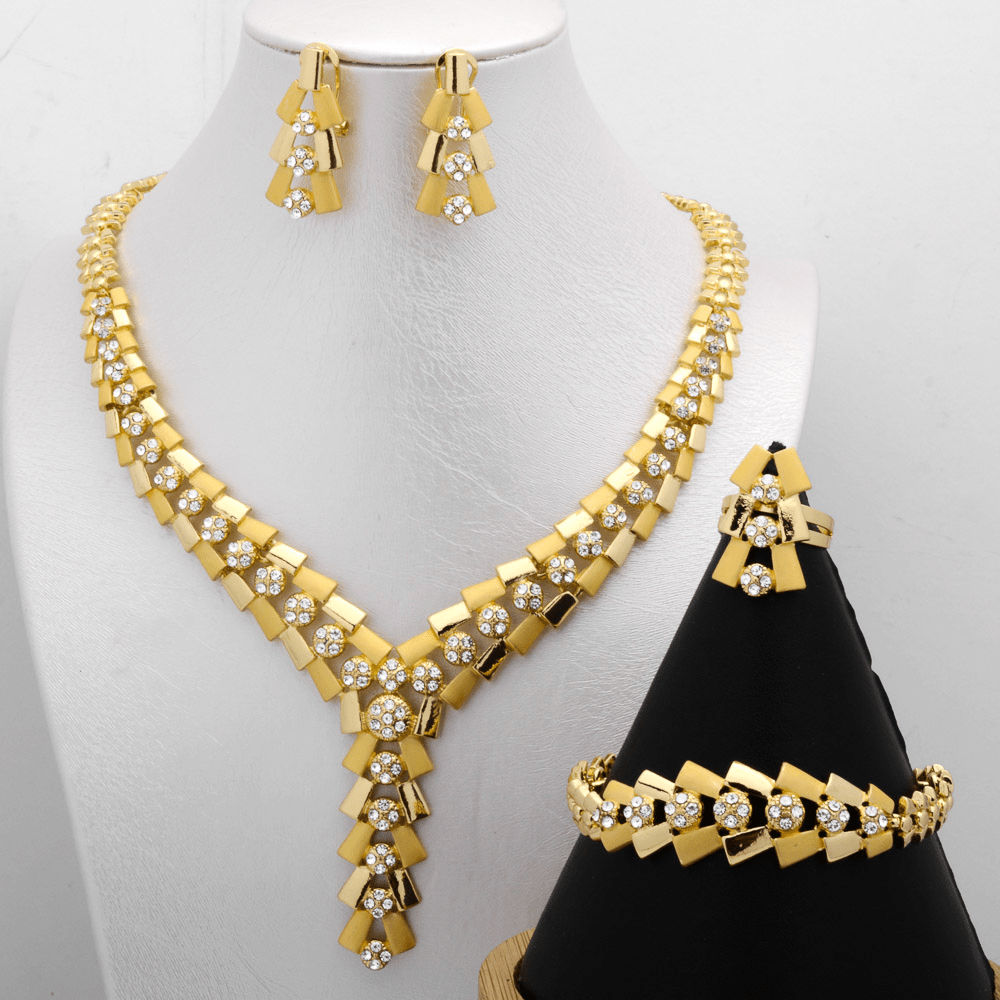 Beautiful copper and zirconia jewelry set for women in a stunning golden tone. Set includes a Y-necklace, earrings, bracelet, and ring with a vintage geometric design. Ideal for parties and weddings.