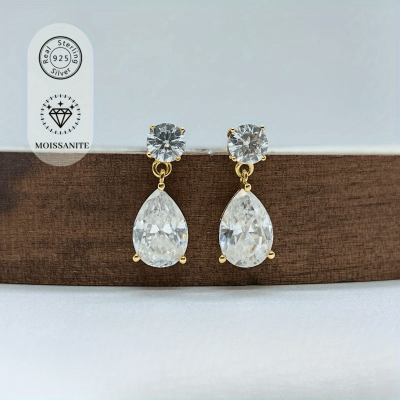 Set of 2 luxurious 18K gold-plated 925 sterling silver stud earrings featuring 2.5 carat pear-cut Moissanite stones. These classic style earrings are perfect for weddings, banquets, or Halloween parties. Each earring is adorned with synthetic November