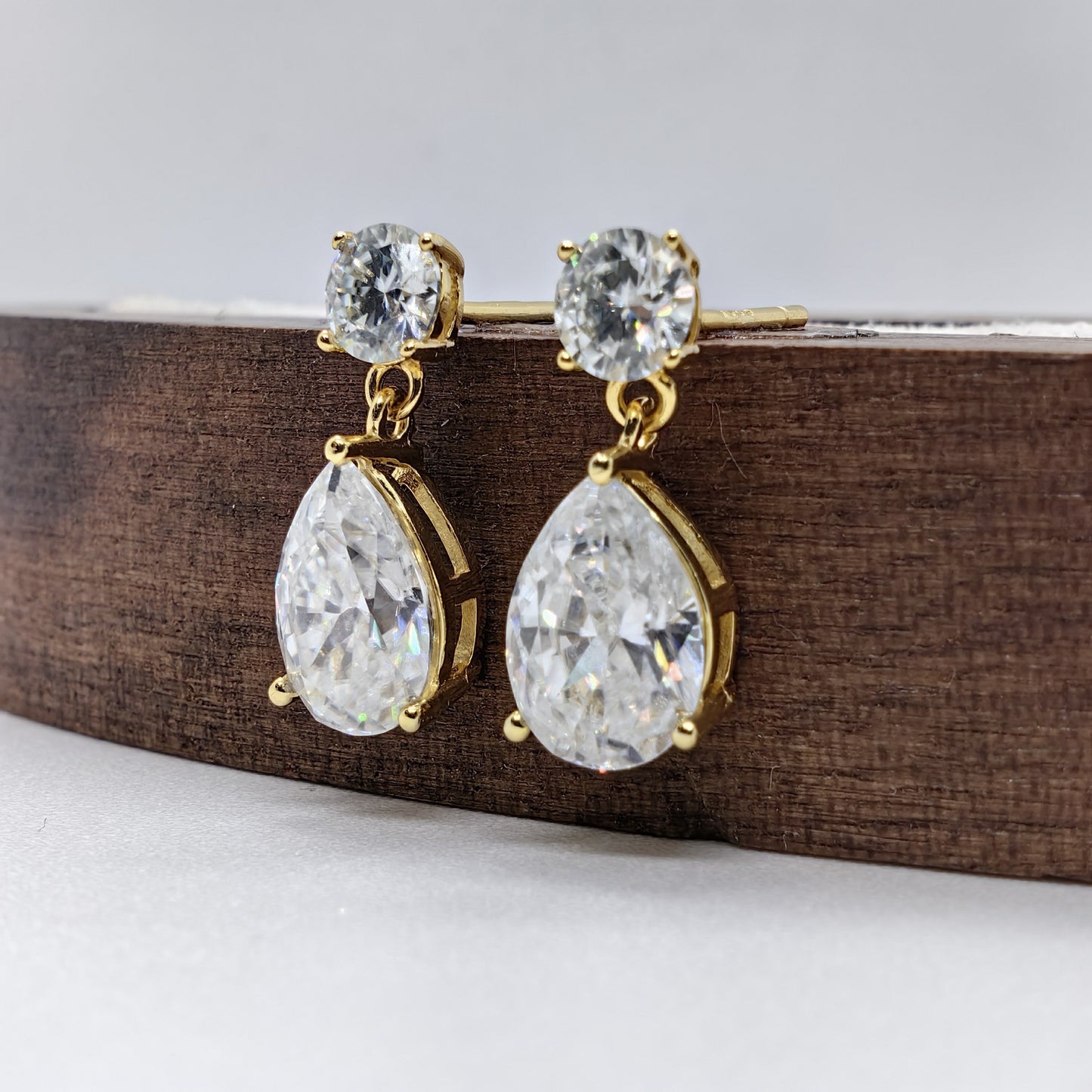 Set of 2 luxurious 18K gold-plated 925 sterling silver stud earrings featuring 2.5 carat pear-cut Moissanite stones. These classic style earrings are perfect for weddings, banquets, or Halloween parties. Each earring is adorned with synthetic November