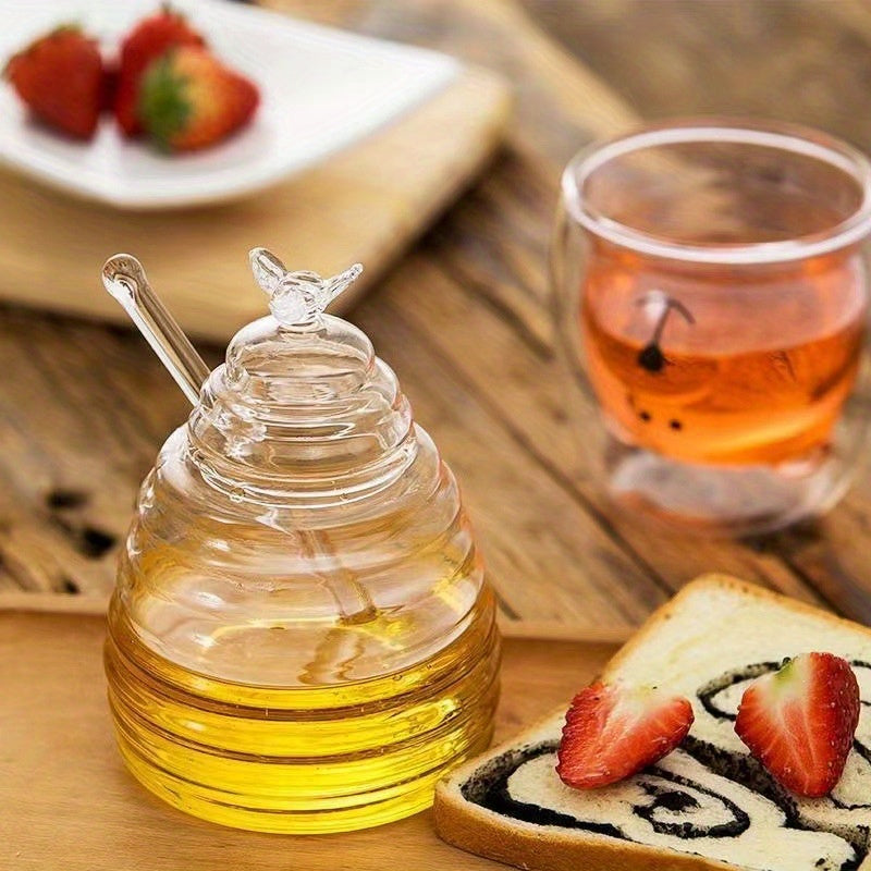 Durable glass honey jar with dipper, 500ml capacity, heat-resistant and safe for transit with pearl packaging. Ideal for syrup, sugar storage, and kitchen use.