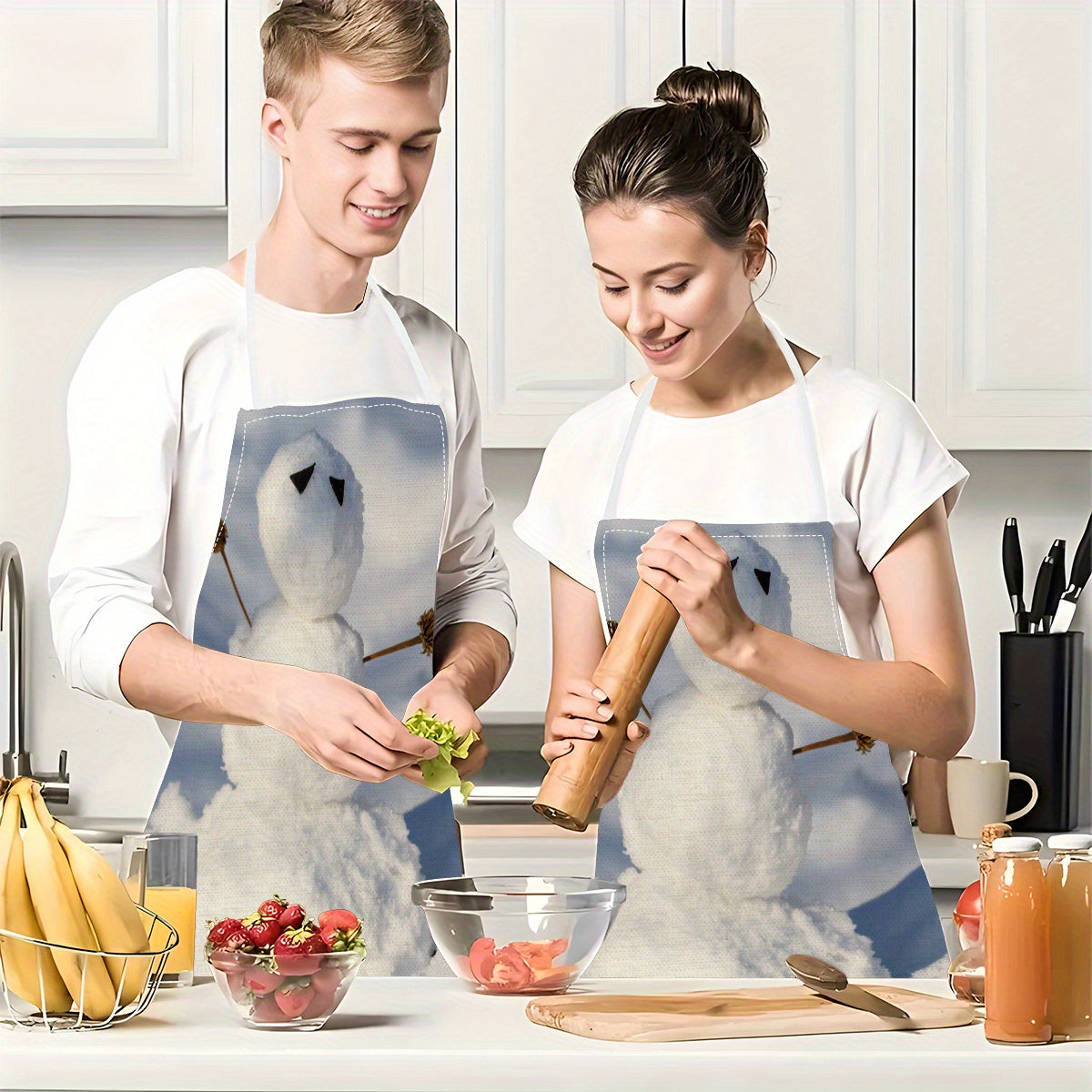 Two festive Christmas kitchen aprons featuring a charming snowman design. Made from 100% polyester, these aprons are adjustable and stain-resistant, perfect for both cooking and cleaning at home and for parties.