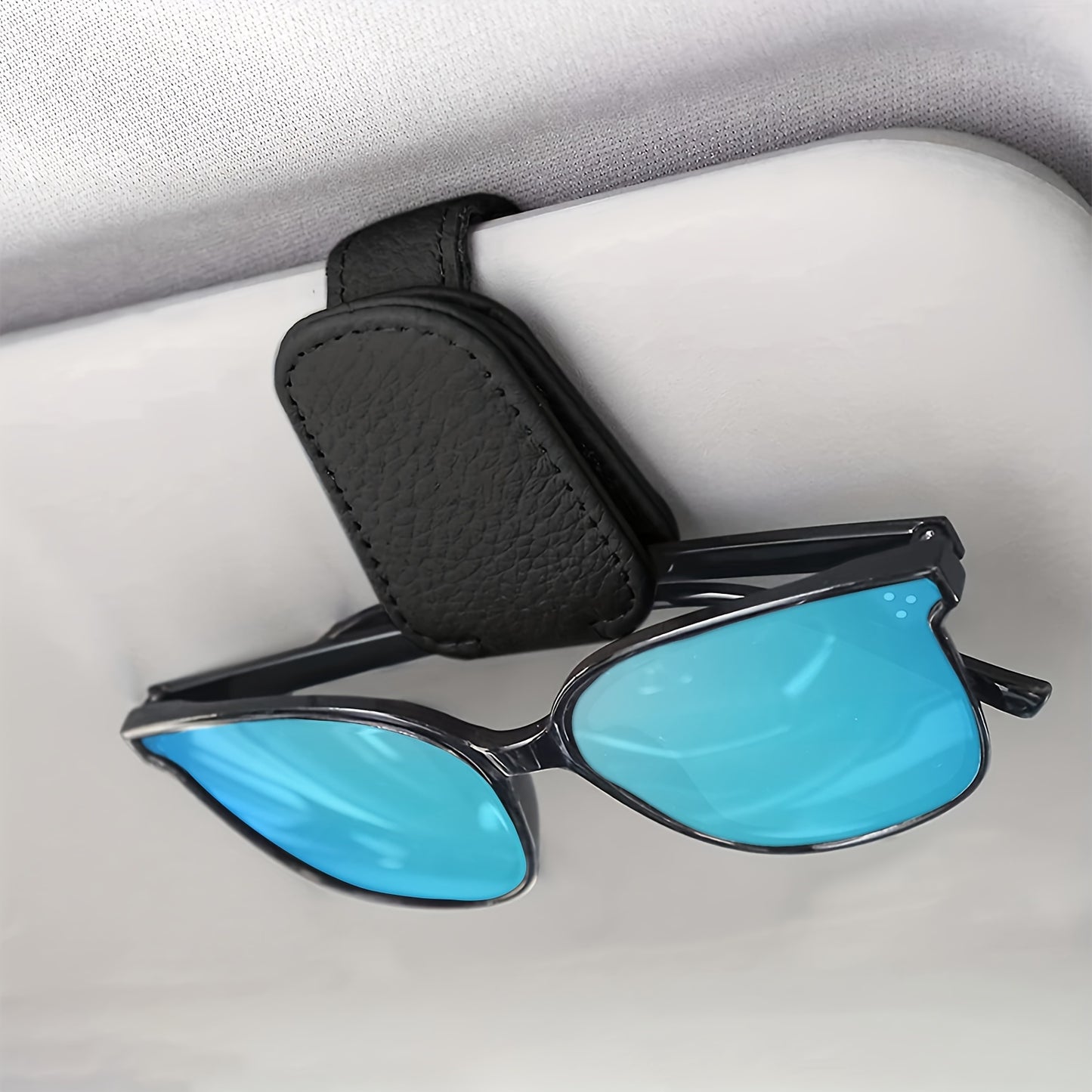 Stylish magnetic PU leather glasses holder for car visor with black textured grip. Compact design for easy access and secure storage.