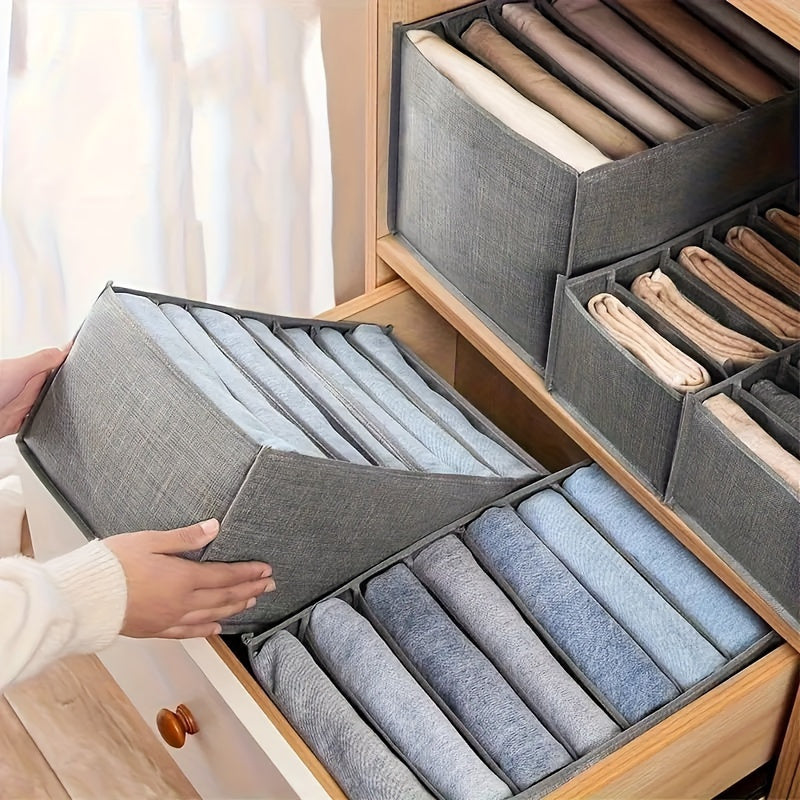 Compact gray storage box with multiple compartments for organizing clothing and books. Features reinforced edges and handle for easy portability. Perfect for small spaces.