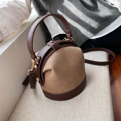 Fashionable women's bucket bag in two-tone brown and beige with gold hardware, ideal for travel and everyday use. Modern tote bag option.