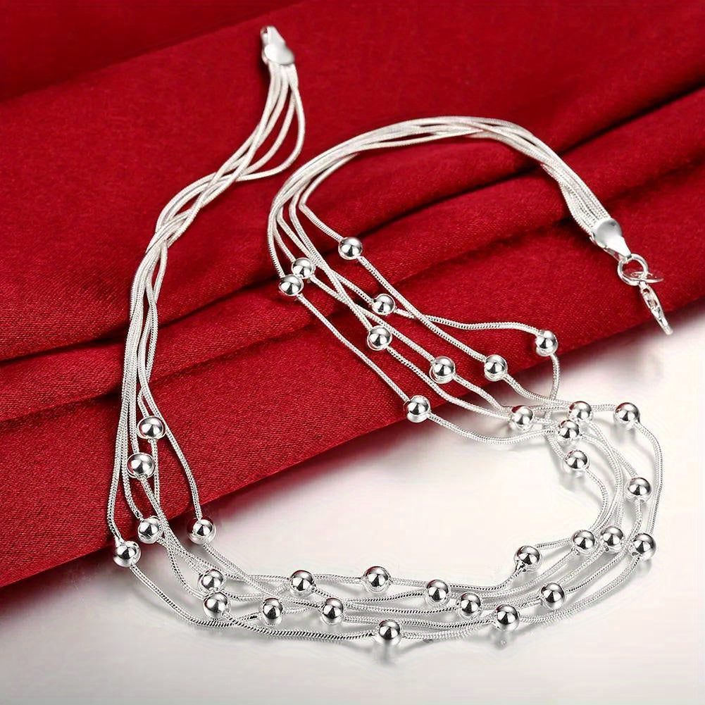 Stunning women's fine jewelry plated in a beautiful sterling silver color necklace. The 45.72cm necklace features five lines of beads on a snake chain, with charm balls for a unique and elegant look. This multilayer necklace is perfect for a lady to wear