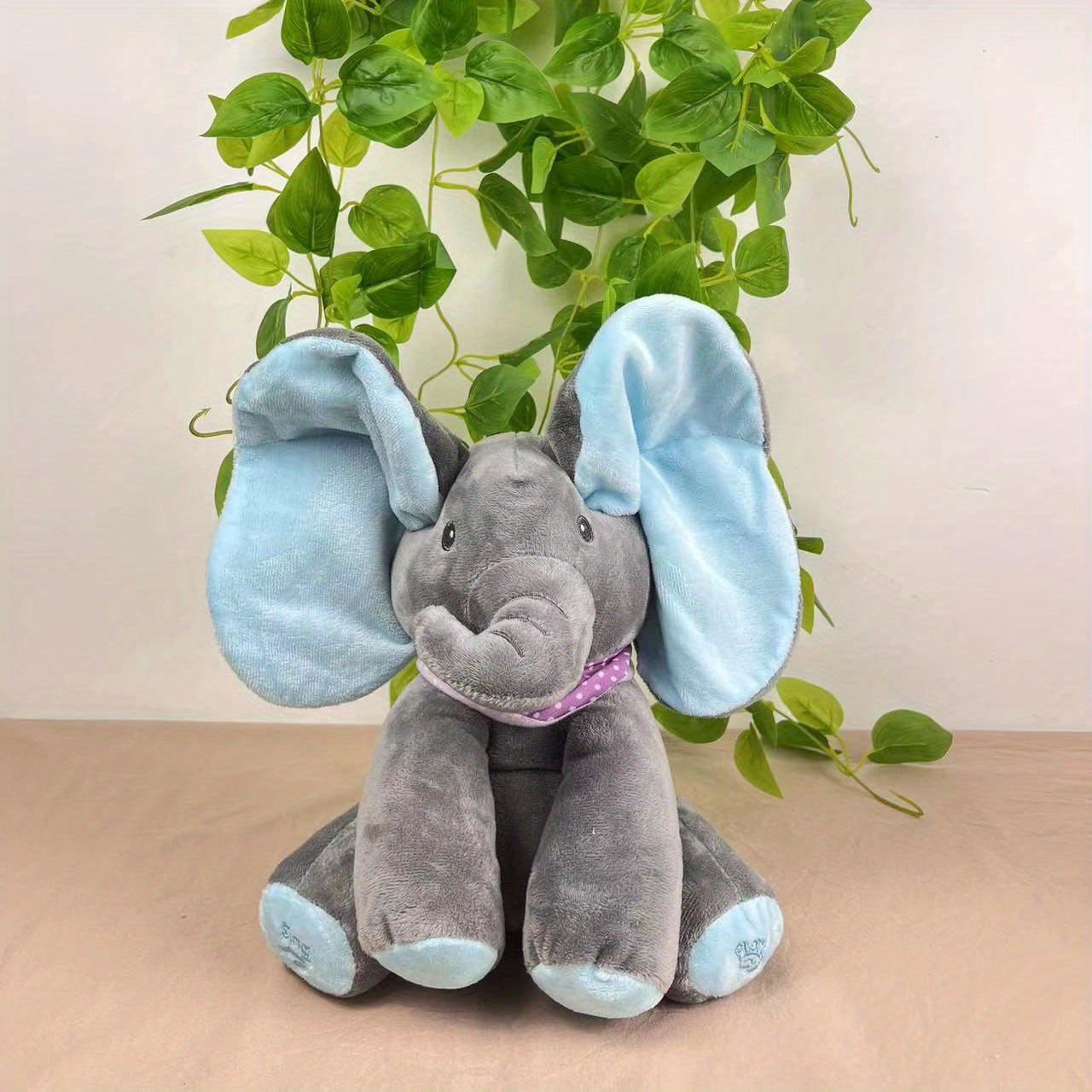 Bright pink and blue interactive elephant plush toy featuring a hide-and-seek game. This singing musical bear doll is designed for girls over 6 years old. Battery operated (AA batteries not included).