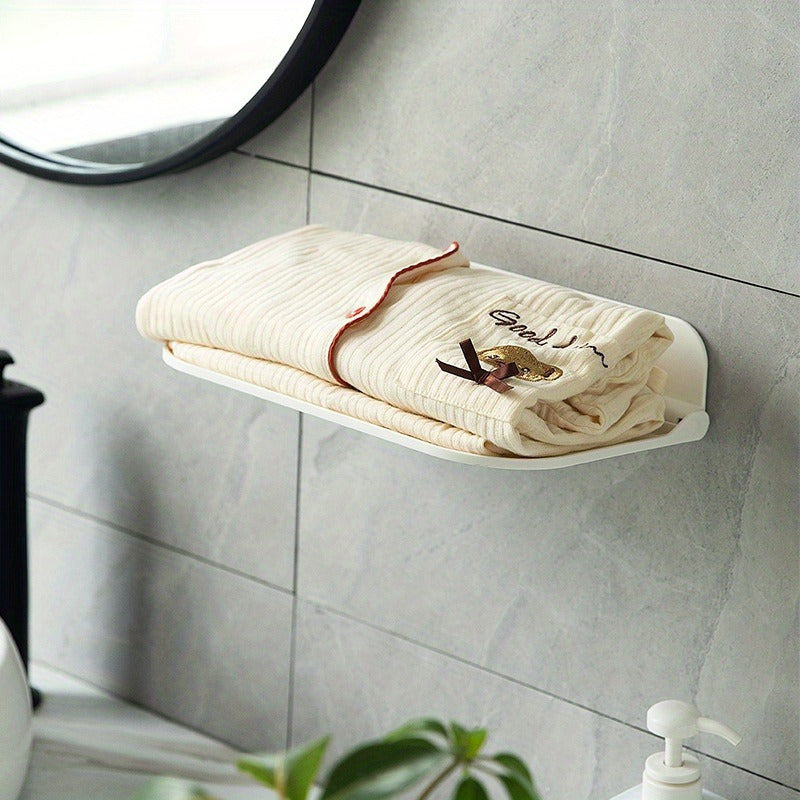 The Wall-Mounted Plastic Storage Shelf with Towel Rack is a versatile organizer for your bathroom. It features a foldable design that requires no drilling for installation. This shelf includes a mobile phone holder, soap dispenser, and paper towel