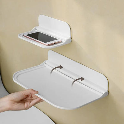 The Wall-Mounted Plastic Storage Shelf with Towel Rack is a versatile organizer for your bathroom. It features a foldable design that requires no drilling for installation. This shelf includes a mobile phone holder, soap dispenser, and paper towel