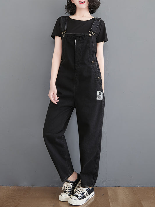 Classic black denim overalls for women with adjustable straps, loose fit, slant pockets and harem hem in non-stretch fabric for all-season wear.