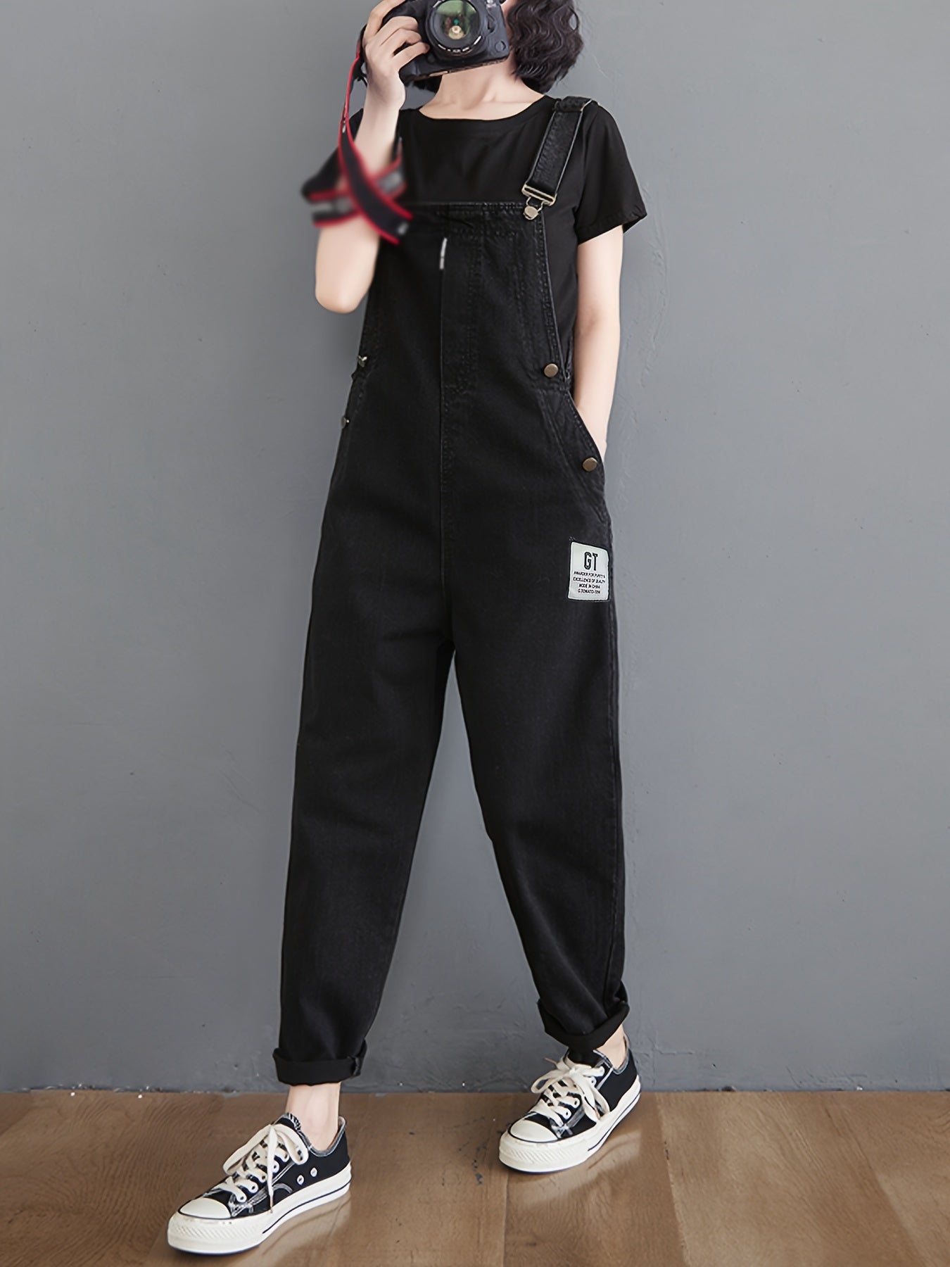 Classic black denim overalls for women with adjustable straps, loose fit, slant pockets and harem hem in non-stretch fabric for all-season wear.