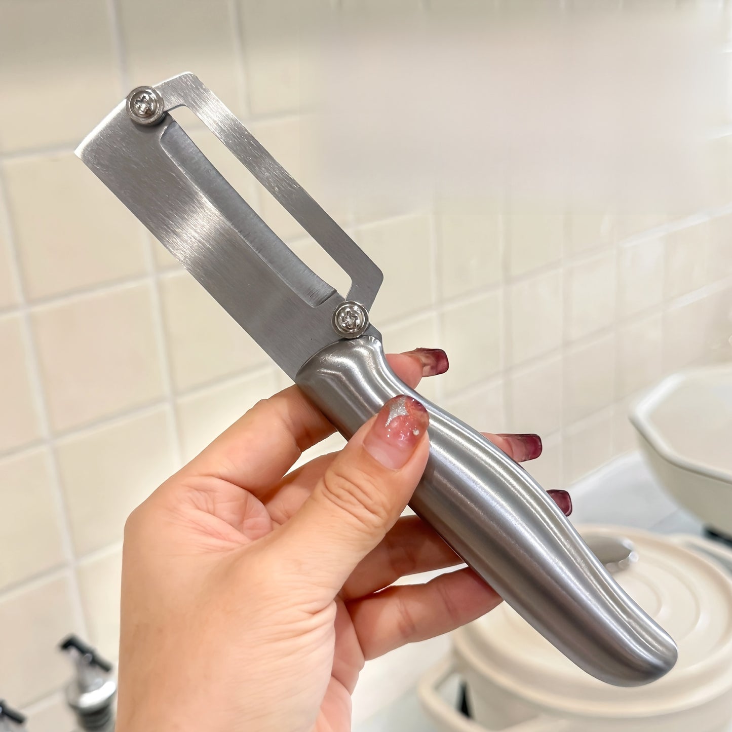 Stainless steel peeler with sharp blade, ideal for various fruits and vegetables including potatoes, pumpkins, and pineapples. Includes bottle opener and vegetable slicer. Essential kitchen tool.