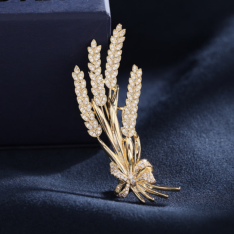 Stylish antique wheat sheaf brooch adorned with a delicate bow and shimmering rhinestones, a nature-inspired fashion accessory for both men and women.