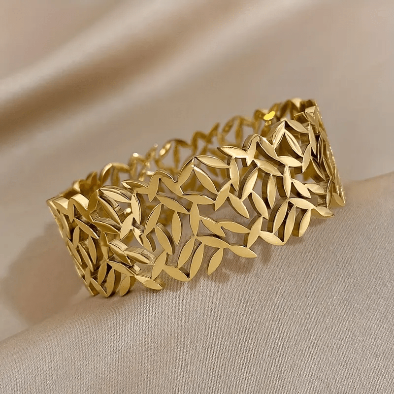 A stylish stainless steel bangle for women, featuring a delicate two-tone design with an irregular hollowed-out leaf bird's nest pattern. This fashionable botanical accessory is perfect for adding a touch of elegance to any outfit and makes a great gift