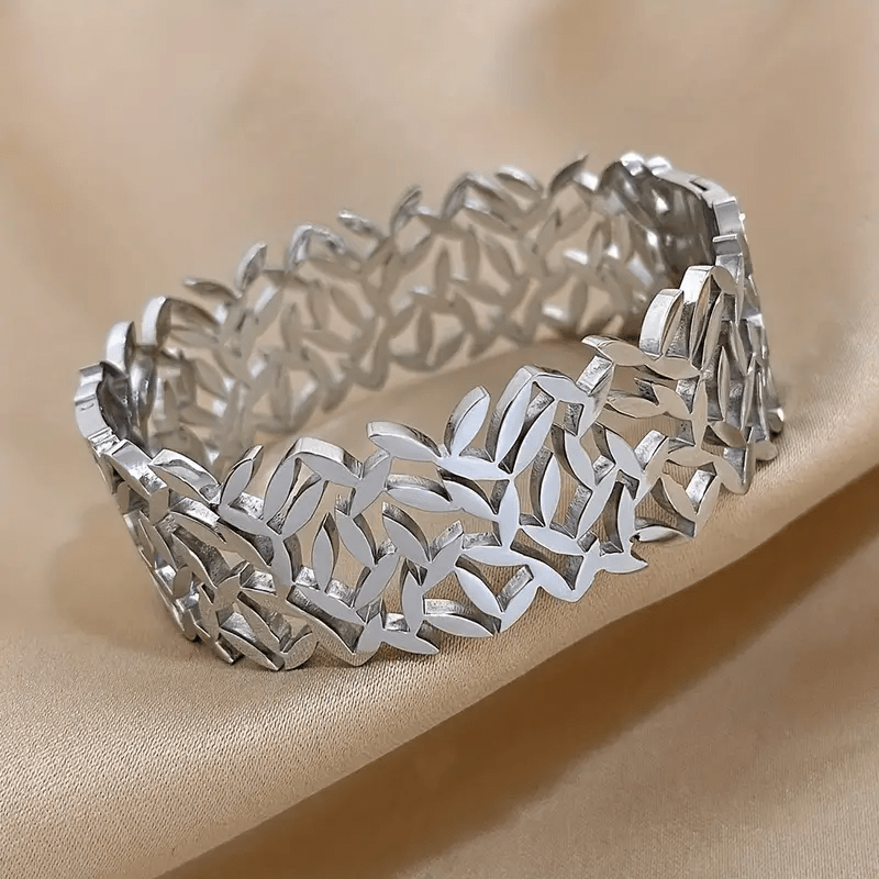 A stylish stainless steel bangle for women, featuring a delicate two-tone design with an irregular hollowed-out leaf bird's nest pattern. This fashionable botanical accessory is perfect for adding a touch of elegance to any outfit and makes a great gift