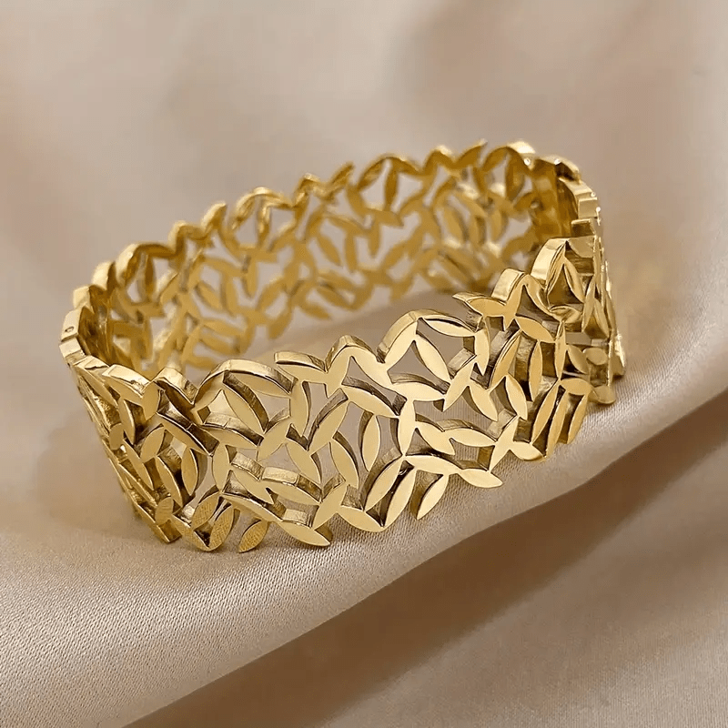 A stylish stainless steel bangle for women, featuring a delicate two-tone design with an irregular hollowed-out leaf bird's nest pattern. This fashionable botanical accessory is perfect for adding a touch of elegance to any outfit and makes a great gift