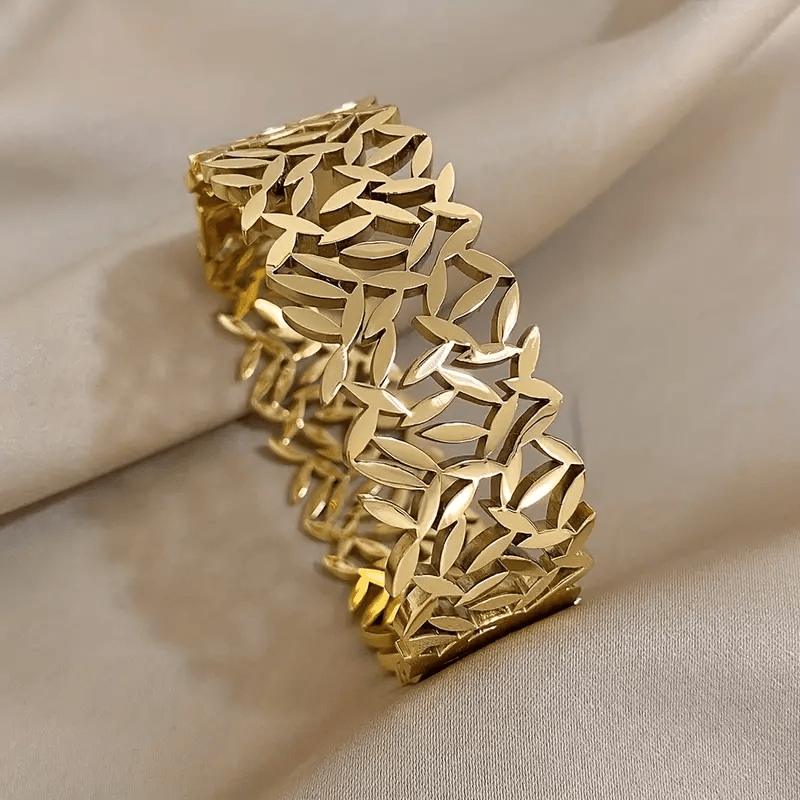 A stylish stainless steel bangle for women, featuring a delicate two-tone design with an irregular hollowed-out leaf bird's nest pattern. This fashionable botanical accessory is perfect for adding a touch of elegance to any outfit and makes a great gift