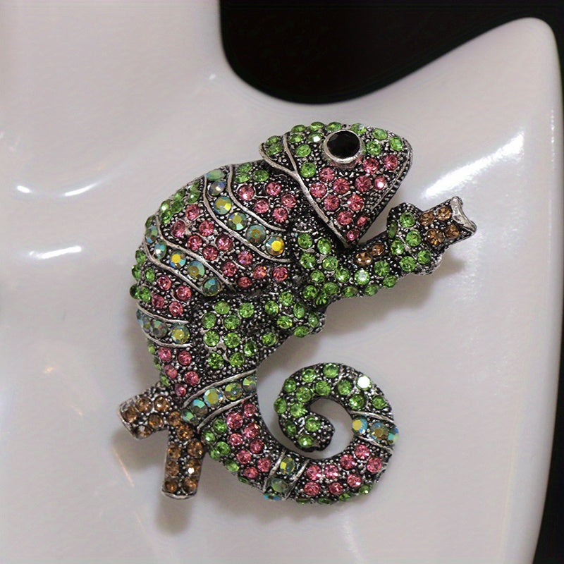 This stylish brooch pin features luxurious rhinestones and is designed in an elegant chameleon shape. The fashionable green and pink crystals adorn the piece, creating a unique and irregular shape. This versatile accessory can be worn as chest jewelry or