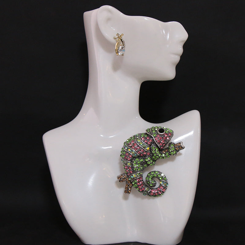 This stylish brooch pin features luxurious rhinestones and is designed in an elegant chameleon shape. The fashionable green and pink crystals adorn the piece, creating a unique and irregular shape. This versatile accessory can be worn as chest jewelry or