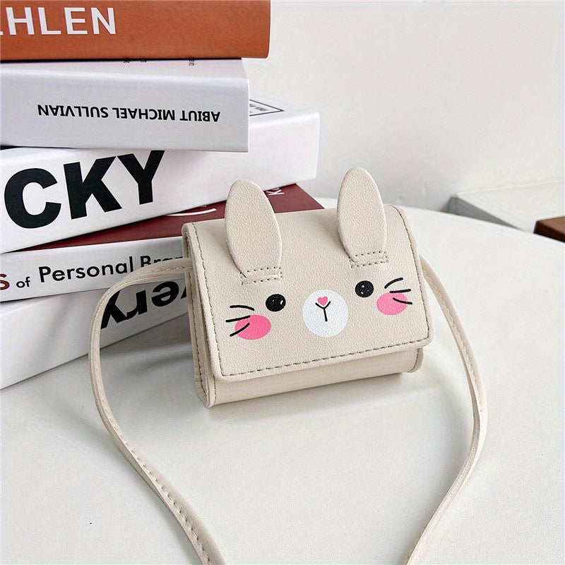 Cute bunny-themed mini crossbody bags in faux leather with adjustable strap. Includes cartoon coin purse and shoulder handbag in various colors. Bunny accessories available.