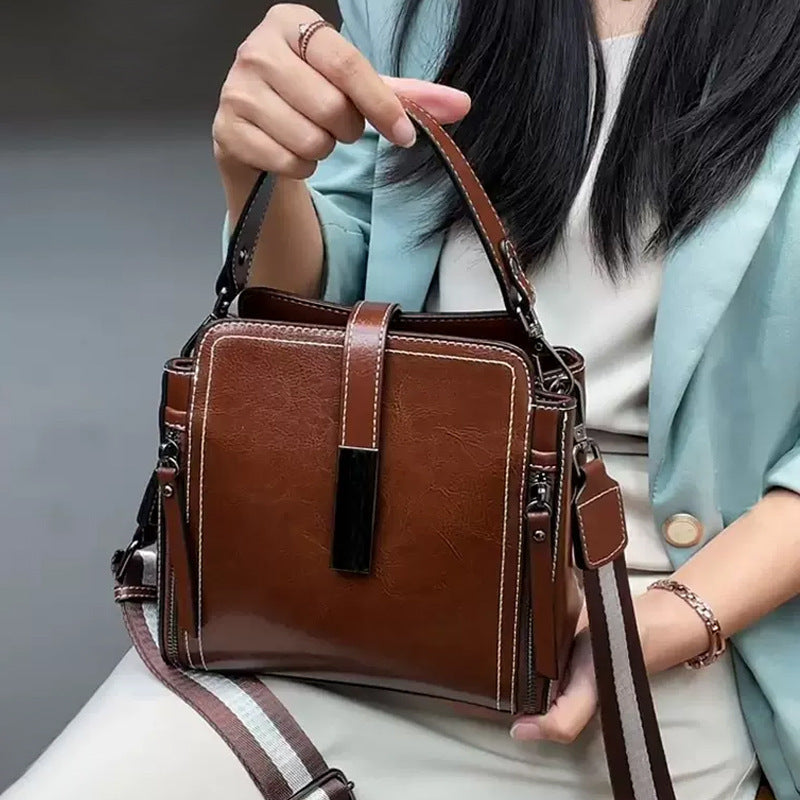 Stylish leather shoulder bag for women with removable strap, zipper closure, and edge paint detail. Available in black, coffee, and light brown.