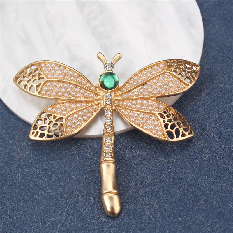 Add a touch of vintage charm with this exquisite Golden Dragonfly Brooch, crafted from luxurious alloy and enamel. Perfect for embellishing dresses, sweaters, and suits with a retro flair. This elegant accessory features a stunning golden dragonfly