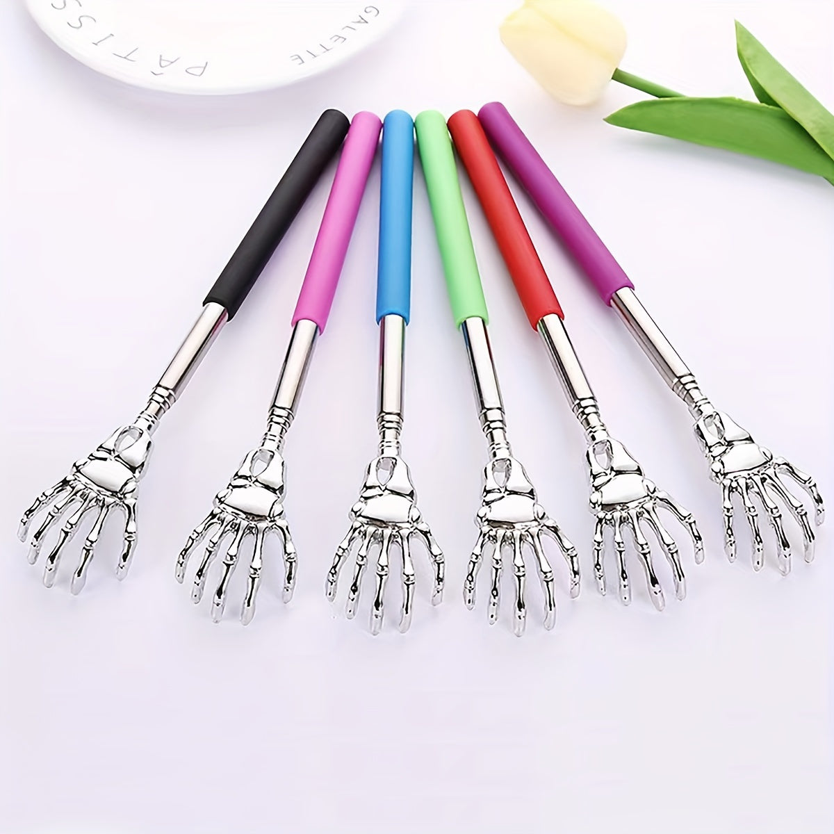 Extendable stainless steel back scratcher and massager with spooky skeleton hand design, adjustable length of 19.05cm to 69.85cm. Portable and durable construction.