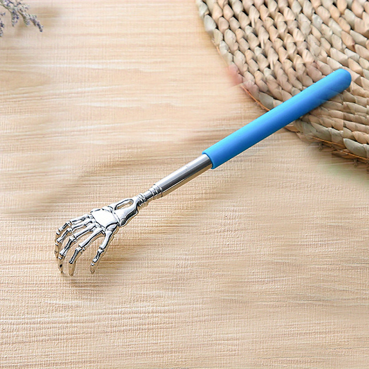 Extendable stainless steel back scratcher and massager with spooky skeleton hand design, adjustable length of 19.05cm to 69.85cm. Portable and durable construction.