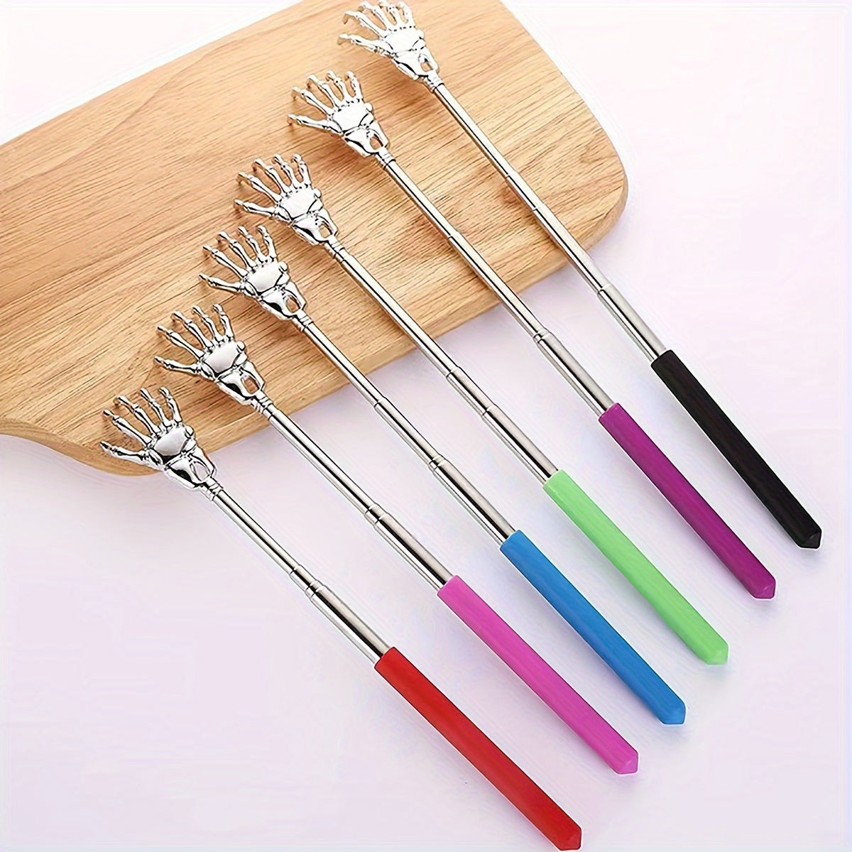 Extendable stainless steel back scratcher and massager with spooky skeleton hand design, adjustable length of 19.05cm to 69.85cm. Portable and durable construction.