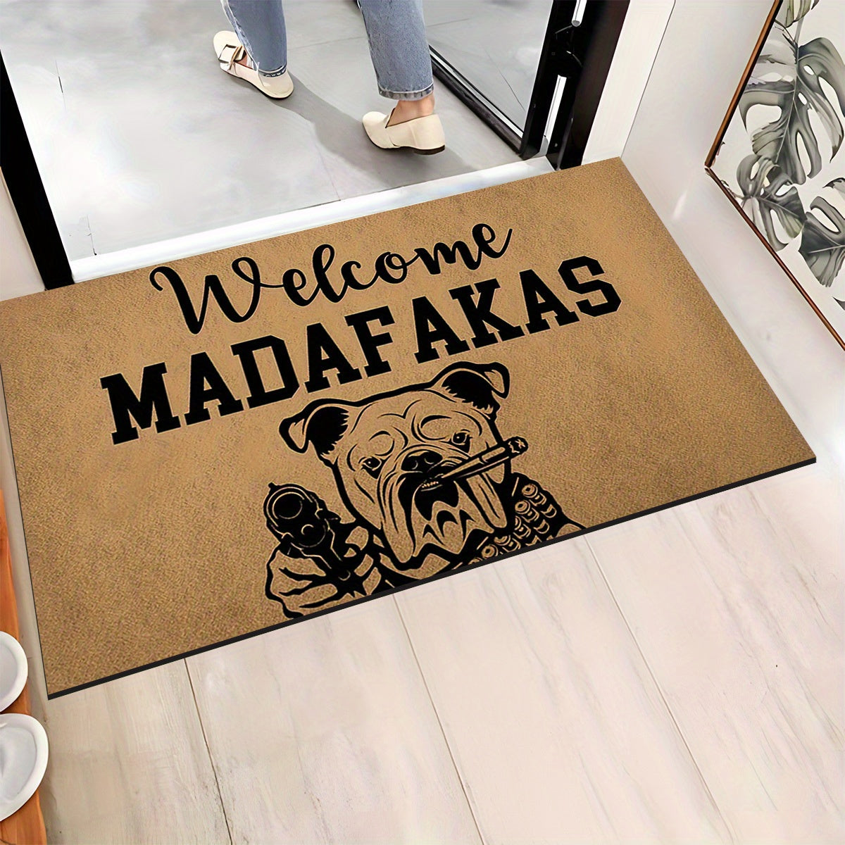 A unique welcome mat featuring a "Welcome Madafakas" design, complete with a dog holding a gun pattern. This anti-slip, absorbent mat is easy to clean and made of crystal velvet carpet material. Perfect for use in entrances, bedrooms, farms, and both