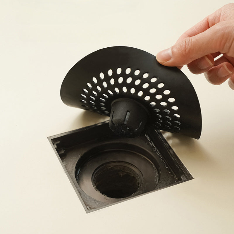 Silicone drain strainer with circular design for shower and kitchen sinks. Available in black or white. Easy to install with drain holes. Ideal for bathroom or kitchen use.