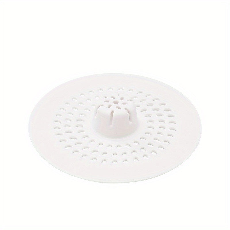 Silicone drain strainer with circular design for shower and kitchen sinks. Available in black or white. Easy to install with drain holes. Ideal for bathroom or kitchen use.