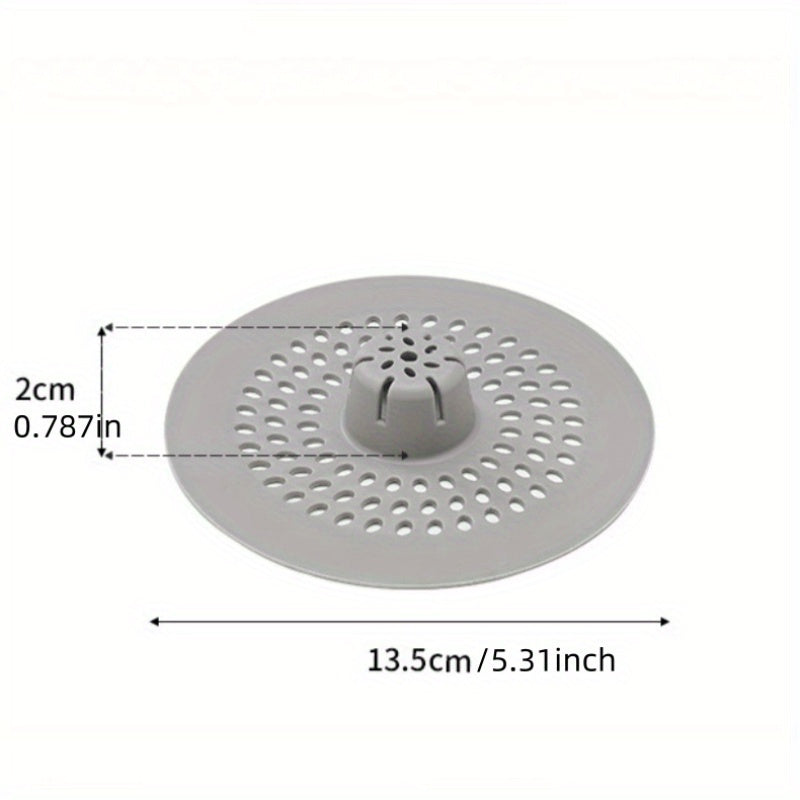 Silicone drain strainer with circular design for shower and kitchen sinks. Available in black or white. Easy to install with drain holes. Ideal for bathroom or kitchen use.