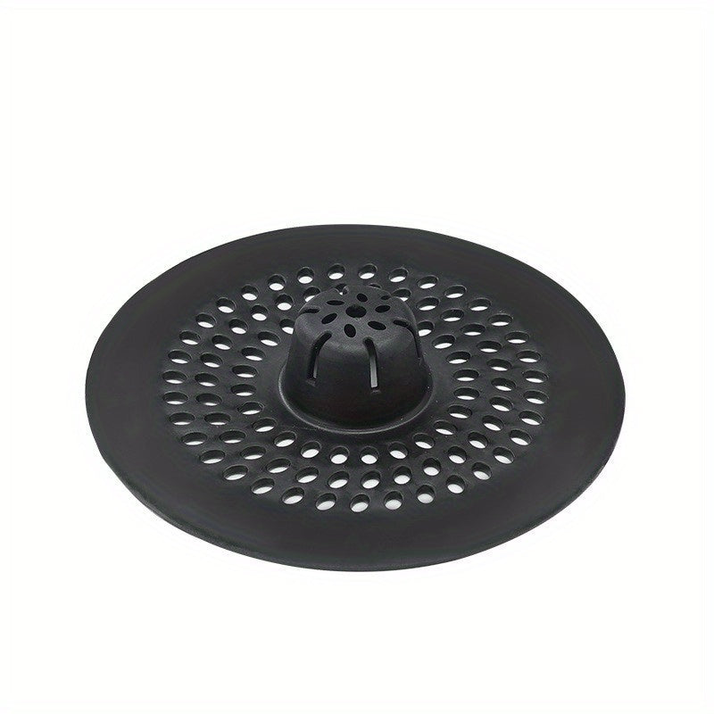 Silicone drain strainer with circular design for shower and kitchen sinks. Available in black or white. Easy to install with drain holes. Ideal for bathroom or kitchen use.