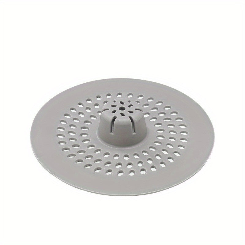 Silicone drain strainer with circular design for shower and kitchen sinks. Available in black or white. Easy to install with drain holes. Ideal for bathroom or kitchen use.