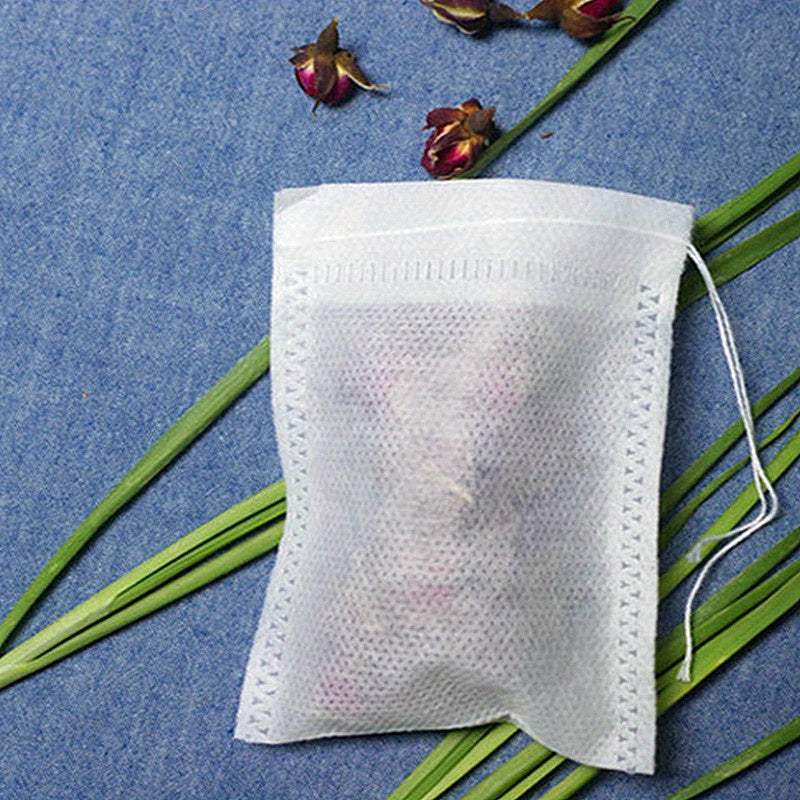 Pack of 100 transparent non-woven tea bags with drawstring, perfect for loose leaf tea and herbs. Convenient disposable pouches for storing and steeping your favorite blends.