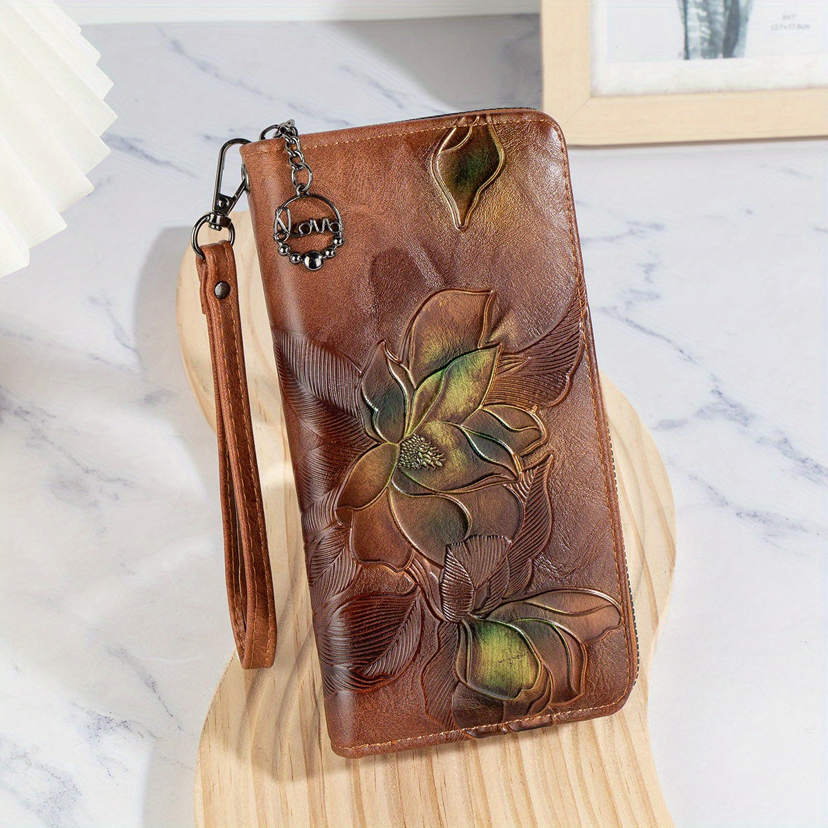 Faux leather clutch wallet with floral embossing, wristlet, zipper closure, multi-card compartment, phone pocket, and long purse design.